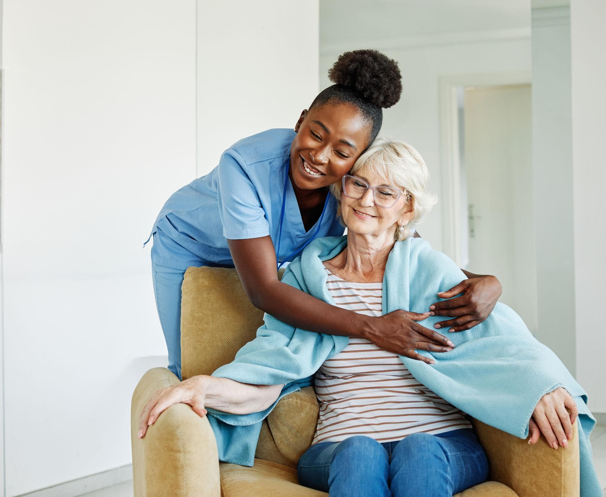 Nurse sharing a warm, reassuring embrace with an elderly resident